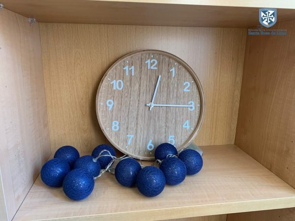 Studium Living - reloj de madera en estantería